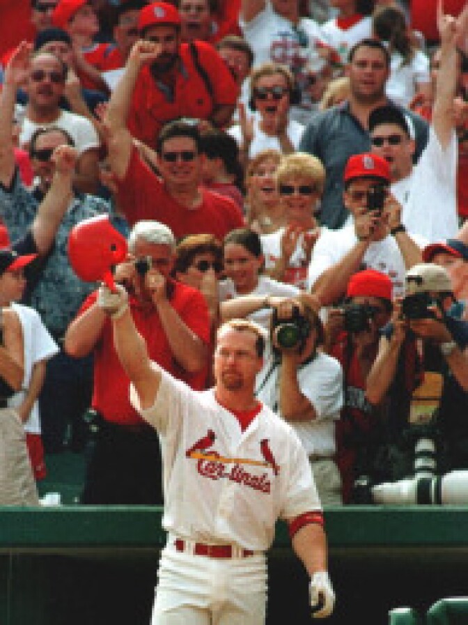 St. Louis Cardinal first baseman Mark McGwire salutes the fans after hitting his 70th home run of the season against the Montreal Expos on September 27, 1998