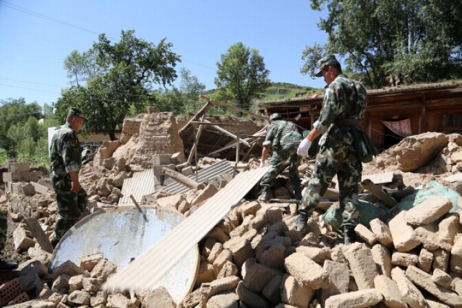 Rescuers rushed to find victims buried by twin shallow earthquakes in northwest China Monday after the double tremors killed at least 75 people and injured almost 600, officials said. (Photo: Rescuers search for survivors in the ruins of a damaged house in Hetuo township in Dingxi, northwest China's Gansu province on July 22, 2013).