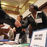  A job seeker shakes hands with a recruiter during the San Francisco Hirevent job fair at the Hotel Whitmore in San Francisco, California. 