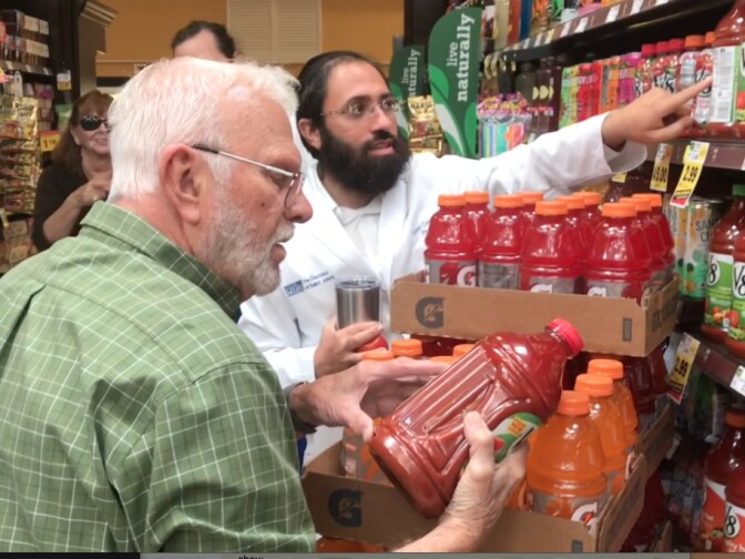 Dr. Daniel Ganjian talks shopper Richard Cook into trying the low-sodium vegetable juice. 
