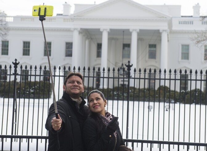 Tourists use a "selfie stick" to take their photograph in front of the White House in Washington, DC, February 18, 2015. AFP PHOTO / SAUL LOEB        (Photo credit should read SAUL LOEB/AFP/Getty Images)
