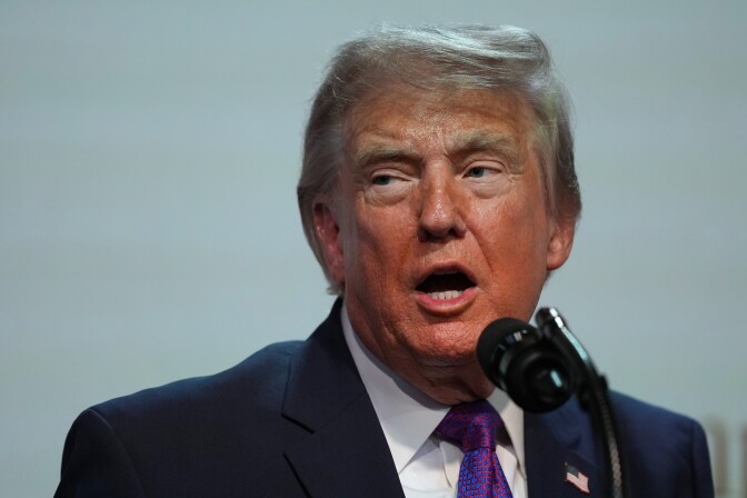 President Trump speaks at a mic.