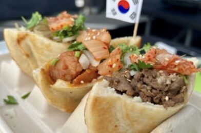 Photo of three pancakes, filled with different meats. They sit all side-by-side in a special tray. There's a small South Korean flag next to the food.