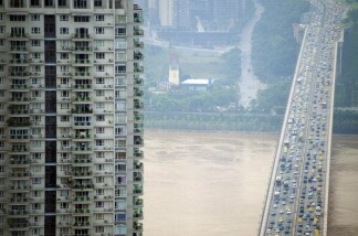 Early morning traffic crosses the Huanhuayuan bridge across the Jialing in southwest China's Chongqing municipality on July 28, 2010.