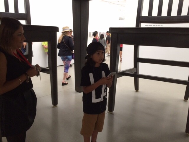 Noah, 10, listens to LeVar Burton's audio tour while standing "Under the Table" at the Broad museum.