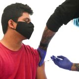 High school student Abraham Alvarado, 17, receives his first Pfizer Covid-19 vaccine administered by Medical Assistants from St. John's Well Child and Family Center at Abraham Lincoln High School in Los Angeles, on April 23, 2021. - In an ongoing effort to encourage students 16 and older to get vaccinated, Los Angeles County is offering free Covid-19 vaccines at large-scale vaccination sites over the weekend till Monday with walk-in innoculations available while supplies last. (Photo by Frederic J. BROWN / AFP) (Photo by FREDERIC J. BROWN/AFP via Getty Images)