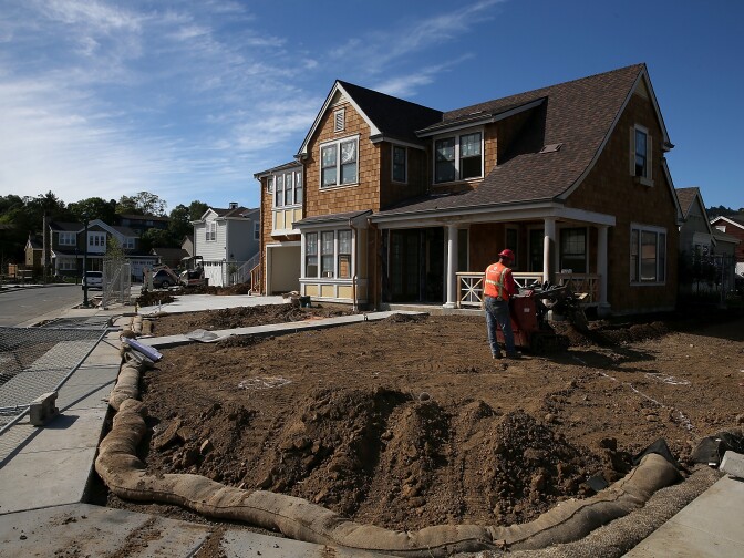 A worker digs a trench in front of a home under construction at a new housing development on March 17, 2015 in Larkspur. California's not just paying people to get rid of their lawns. The state's also sharply curtailing how much grass is permitted in landscaping around newly constructed homes and complex remodeling projects at old ones. 