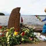 A young boy lays a flower opposite Utoya Island, following Friday's twin extremist attacks on July 25, 2011 in Utoya, Norway.