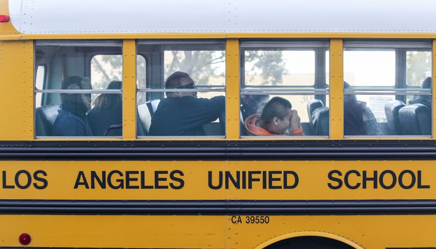 File: A school bus arrives at a school in Los Angeles on Dec. 16, 2015.