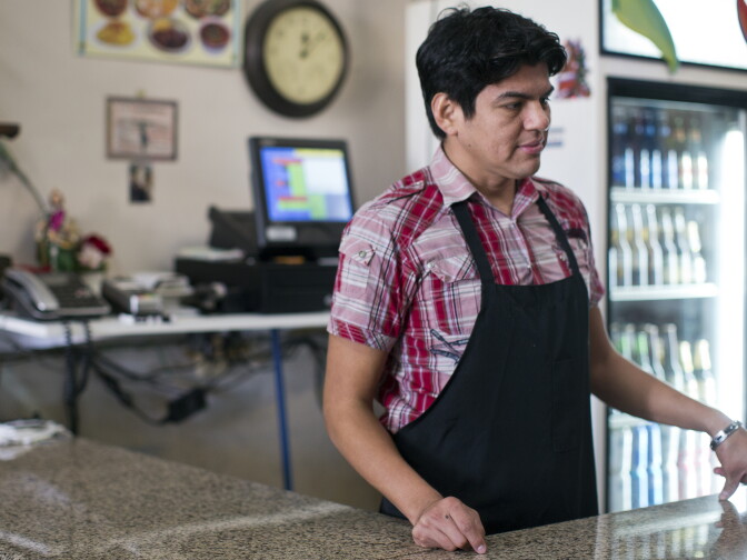 Pancho Cazuelas helps a customer with a to-go order on Wednesday, Jan. 15 at Cazuelas Panchito in downtown Santa Ana. Cazuelas' mother opened the restaurant three months ago. His family previously owned a video store in Lake Forest.
