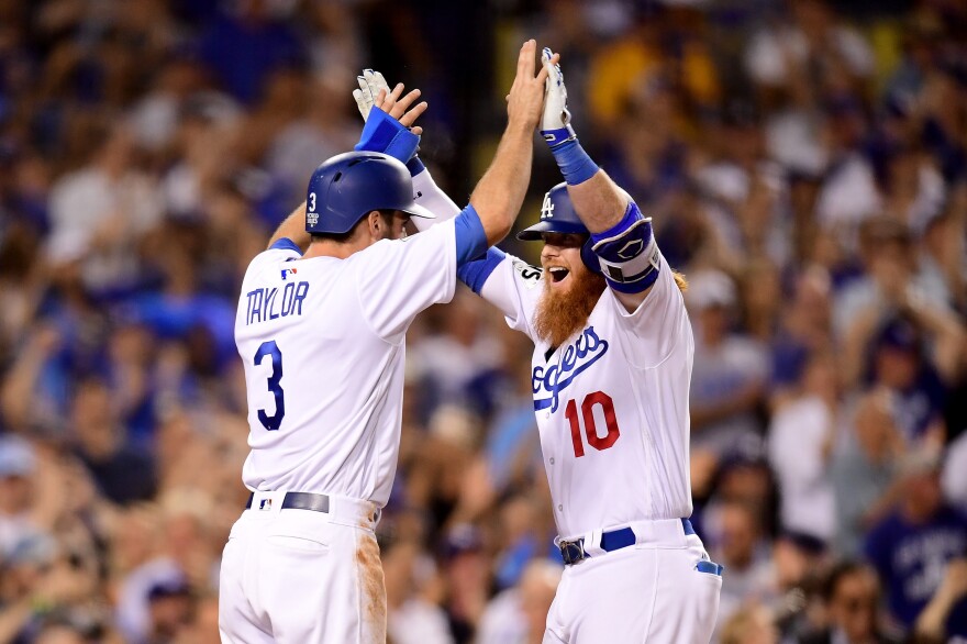 Justin Turner of the Los Angeles Dodgers celebrates with Chris Taylor after hitting a two-run home run during the sixth inning against the Houston Astros in game one of the 2017 World Series at Dodger Stadium on Oct. 24, 2017.