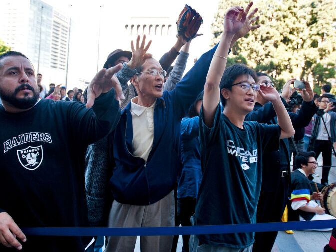Fans answer trivia questions about Ryu, to win baseballs. Hundreds filled the Koreatown plaza to take pictures and get autographs.
