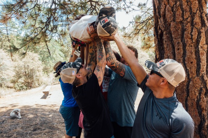 Jesus Guzmán (right) and fellow Higher Ground veterans participate in a team-building exercise during a hike in Big Bear, CA.