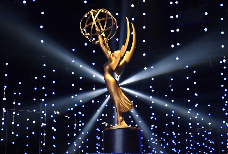 A photo of the golden Emmy award with a dark background.