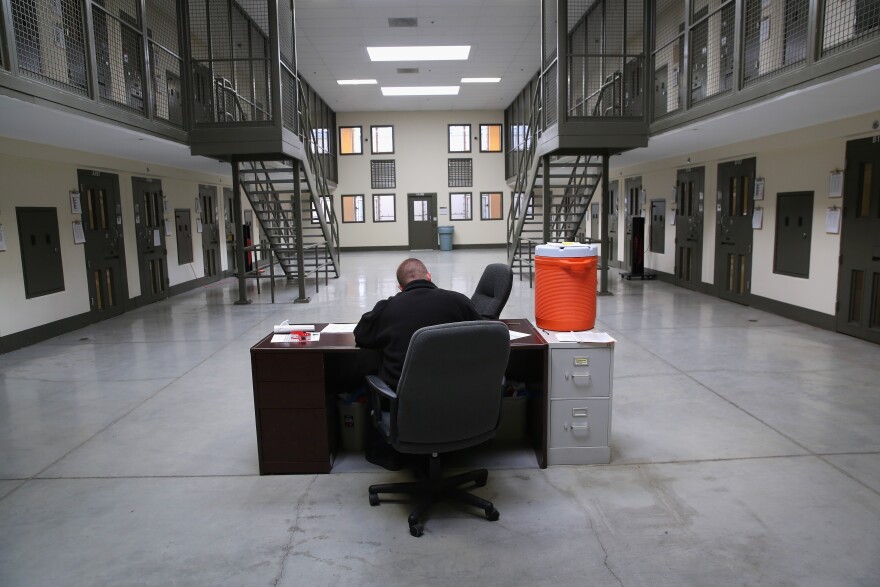 ADELANTO, CA - NOVEMBER 15: A guard sits in the 'segregation block' at the Adelanto Detention Facility on November 15, 2013 in Adelanto, California. Most detainees in segregation cells are sent there for fighting with other immigrants, according to guards. The facility, the largest and newest Immigration and Customs Enforcement (ICE), detention center in California, houses an average of 1,100 immigrants in custody pending a decision in their immigration cases or awaiting deportation. The average stay for a detainee is 29 days. The facility is managed by the private GEO Group. ICE detains an average of 33,000 undocumented immigrants in more than 400 facilities nationwide. (Photo by John Moore/Getty Images)