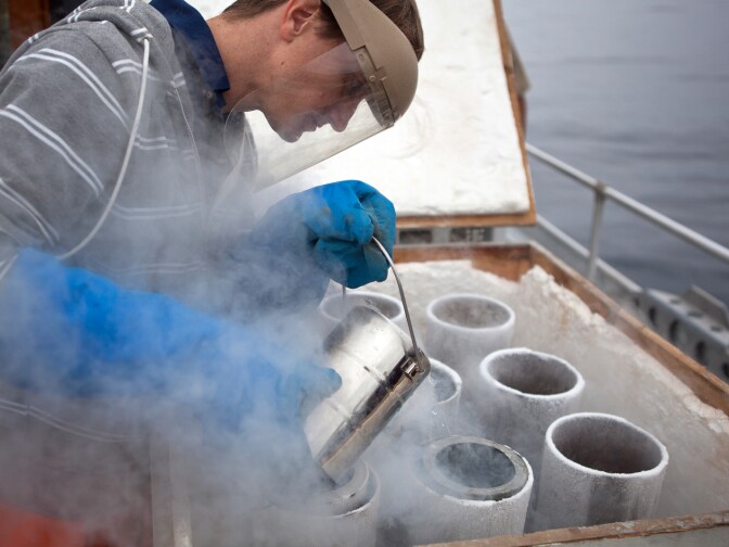 Sanitation Districts of LA County Biologist Chase McDonald pours dry ice around the sediment sample to freeze it.