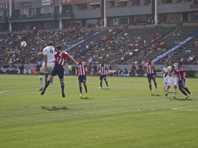 Chivas USA players, in red-and-white-striped jerseys, battle the L.A. Galaxy in March 2013. Two former coaches with the Chivas USA youth academy have filed a lawsuit, claimng the organization discriminated against them for not being Latino. The soccer organization has issued a statement saying it respects diversity. 