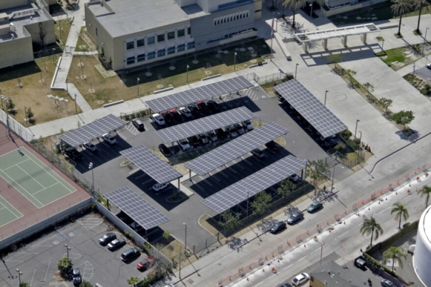 An aerial shot of solar panels on shade structures over a parking lot.