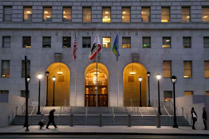 LOS ANGELES, CA-OCTOBER 12, 2017:  A pedestrian walks past the Hall of Justice on Spring St. in downtown Los Angeles on October 12, 2017. 