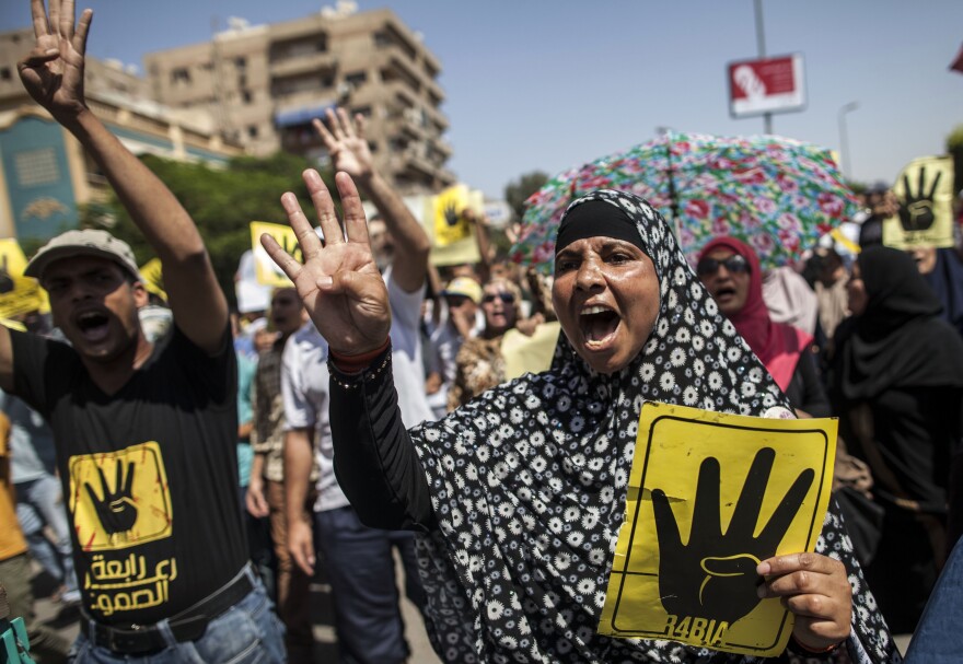 Supporters of ousted Egyptian president Mohamed Morsi raise up posters with the four finger symbol during a demonstration against the military backed government in the Egyptian capital Cairo, on September 13, 2013. An Egyptian court Monday banned all Muslim Brotherhood activity and seized the group's financial assets.