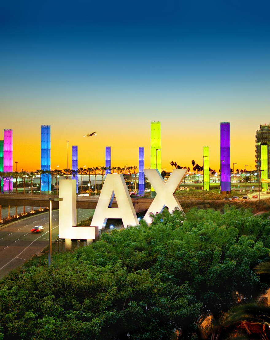 An image of the LAX Airport entrance lit up with Pride colors.
