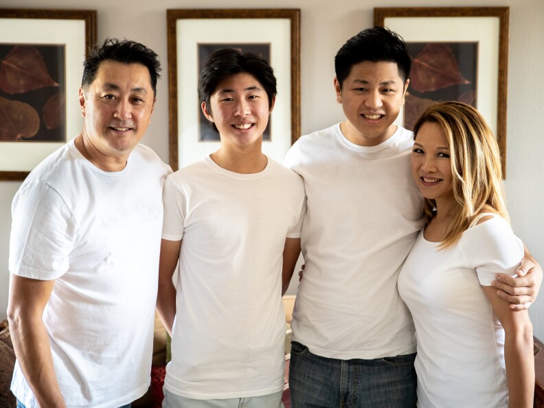 An Asian family of four dressed in white shirts stand together to smile at the camera. From left, Schwan, Jason, Max and Miki Park in 2020.
