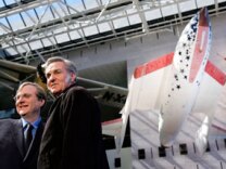 Paul Allen (L), founder and Burt Rutan (R), designer of SpaceShipOne pose for photographs following a news conference to mark the donation of SpaceShipOne (shown in background) to the National Air and Space Museum October 5, 2005 in Washington, DC.