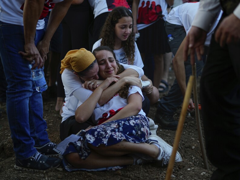 Mourners gather around the graves of British-Israelis Lianne Sharabi and her two daughters, Noiya,16, and Yahel,13, during their funeral in Kfar Harif, Israel, Wednesday, Oct. 25, 2023.