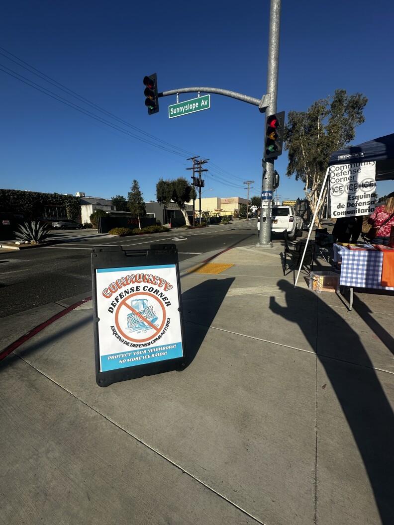A table is set up on a sidewalk near a streetlight.