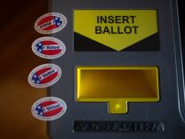 A vote-counting machine and voting stickers.