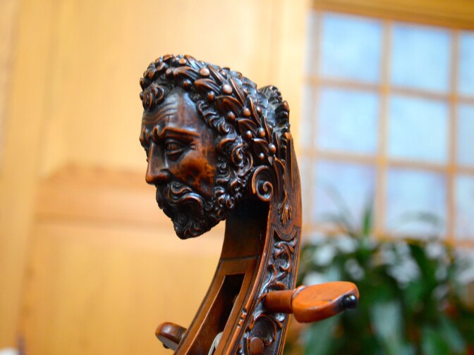 A traditional carved head on an original, early 18th-century bass viol.