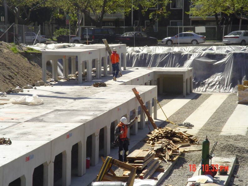 Concrete caverns to filter water underground are under construction. Workers walk atop the caverns