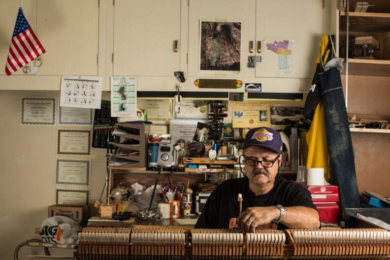 Enrique Beruman fixes the action of the keys on dismantled piano. He is one of three piano technicians on staff at the Music Repair Shop.