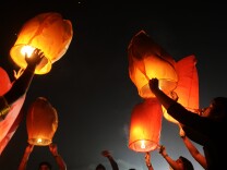 Indian volunteers of a social organization release sky lanterns to promote a peaceful and eco-friendly Diwali and create awareness against child labour in the fire cracker industry during a function in Kolkata on October 30, 2013. Diwali, the Festival of Lights, marks victory over evil and commemorates the time when Hindu god Lord Rama achieved victory over Ravana and returned to his kingdom Ayodhya. 