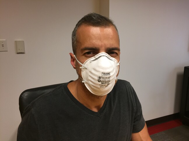 A man tries on a surgical mask.