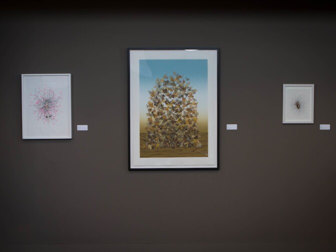 Sonia Romero's painting, Bee Pile, is flanked by two works of Enrique Castejon in Southern California Public Radio's Crawford Family Forum.