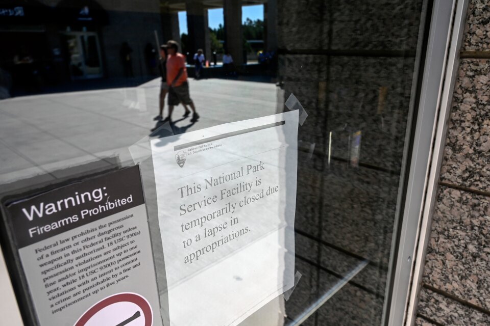People can be seen in the reflection of the Information Center front doors.