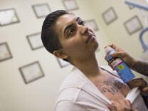 Liliana Flores, 19, finishes a tattoo removal session at Homeboy Industries on Wednesday afternoon, April 15, 2015. More than a year after being released from juvenile prison, Flores is now a student at Pierce College.