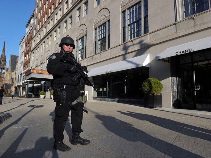 A heavily armed Boston police officer stands guard in front of the Taj Hotel April 16, 2013 in Boston, Massachusetts, in the aftermath of two explosions that struck near the finish line of the Boston Marathon April 15. A massive probe was underway Tuesday after two bombs struck the Boston Marathon, killing at least three and wounding more than 100.