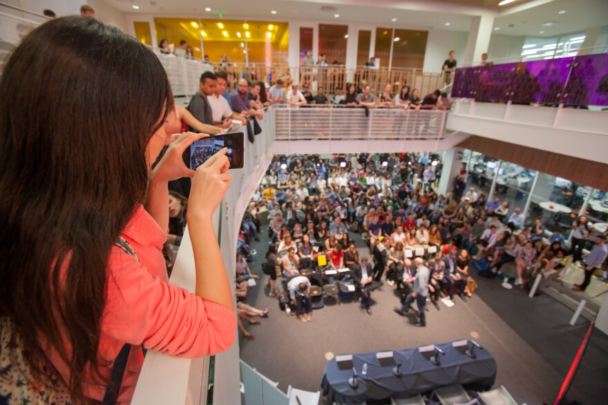 A USC student takes a photo of fellow students and faculty during the third presidential debate at USC Annenberg's Wallis Annenberg Hall on Oct. 19, 2016. 