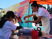 Eli Martinez, one of the members of the team behind La Troka, a new mobile garden classroom teaches children how to make pots out of newspaper and plant seeds.