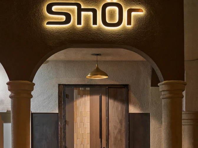 An entrance with two beige columns for the Pakistani restaurant Shor. 
