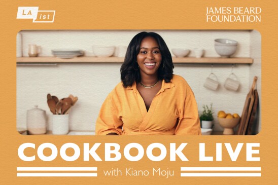 Promotional image on a yellow background with a photograph of Kiano Moju an African American female wearing a yellow blouse. Shelving with plateware, kitchen utensils, cutting boards, a bowl with oranges are in the background of the image. Underneath the picture text reads “Cookbook Live with Kiano Moju” and on top of the image on the left side the LAist logo and on the right side the James Bear Foundation logo. 