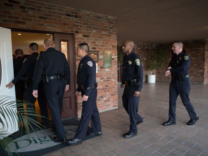 Riverside officers walk into the Acheson and Graham Mortuary in Riverside, Calif. before the procession for Michael Crain, a Riverside Police Officer who was gunned down by Christopher Dorner, on February 13th, 2013.