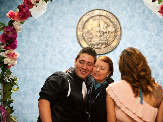 Volunteer Elizabeth Oakes hugs the couple after their wedding ceremony. Although Oakes performs up to 20 weddings per day, she takes time to talk to each couple.