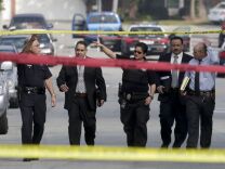 Law enforcement members look over the scene of an officer involved shooting in Torrance, Calif. Thursday, Feb. 7, 2013. Thousands of police officers throughout Southern California and Nevada hunted for a former Los Angeles officer, Christopher Dorner, who was angry over his firing and began a deadly shooting rampage that he warned in an online posting would target those on the force who wronged him, authorities said.