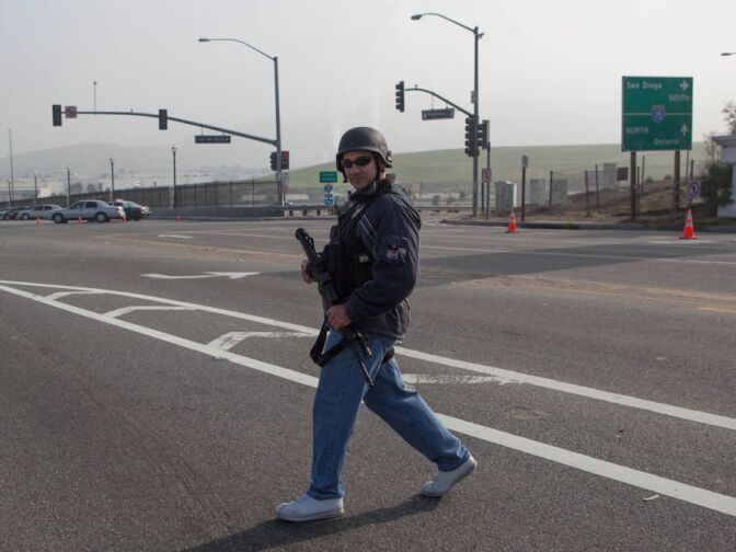 An LAPD officer guards a highway overpass where two officers were shot in what police describe as an ambush. Officers are searching for Christopher Dorner in connection with a string of homicides.
