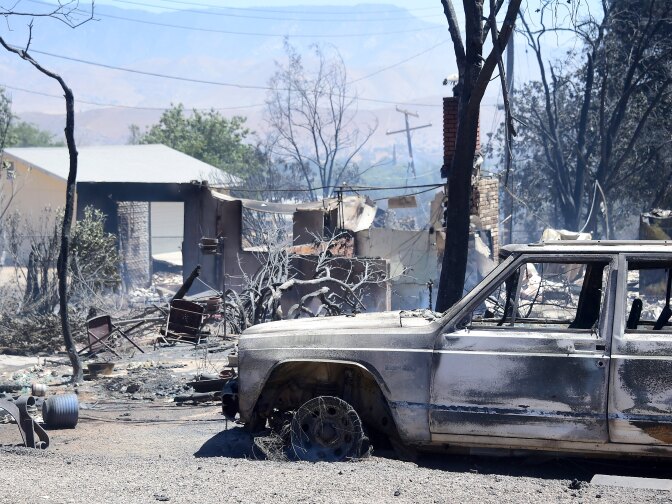 The remains of a demolished home with vehicle out front are seen in the community of Squirrel Valley in Lake Isabella, California on June 24, 2016.