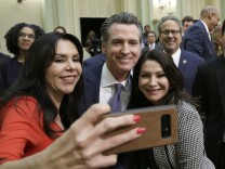 California Gov. Gavin Newsom poses for a selfie with Los Angeles area Democratic lawmakers, Assemblywoman Blanca Rubio, left and her sister state Sen. Susan Rubio, right, after delivering his first State of the State address to a joint session of the legislature at the Capitol Tuesday, Feb. 12, 2019, in Sacramento, Calif. (AP Photo/Rich Pedroncelli)