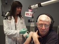 CVS Pharmacist Jill Kolin administers a flu shot to KPCC's Morning Edition Anchor Steve Julian. 